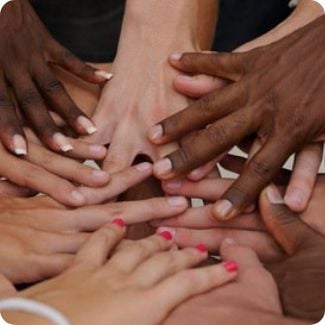 Hands of many different races touching - World Transformation Movement Commendations