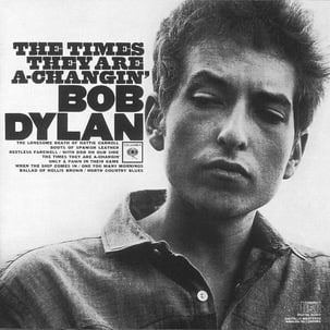 Bob Dylan and the text ‘The times they are a-changin’ on his album cover