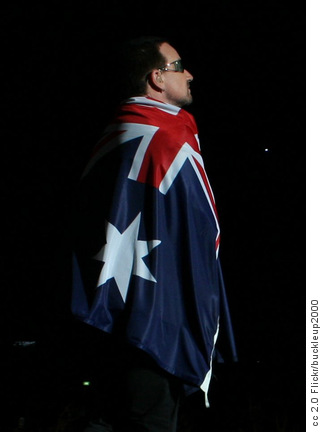 Bono of the band U2, on stage drapped in an Australian flag, in Sydney, Australia during the 2006 Vertigo Tour.