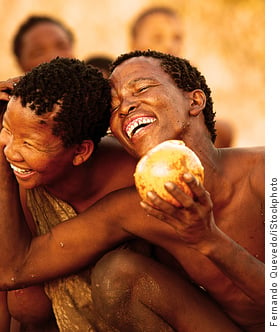 Kalahari bushmen smiling holding melon
