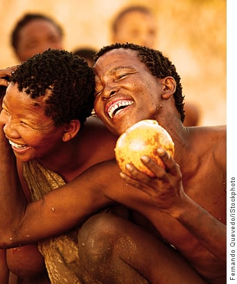 Kalahari bushmen smiling holding melon