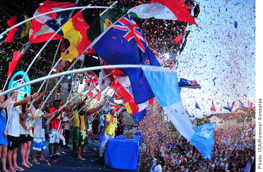 Image of people on a stage waving many different national flags celebrating together