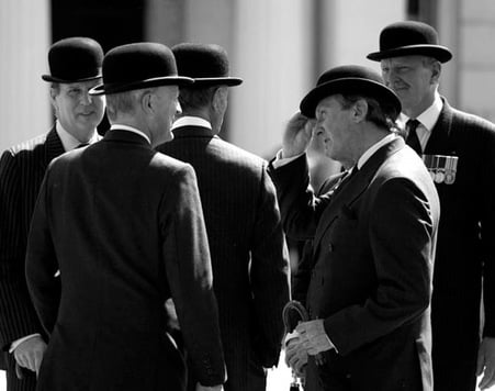 A group of Englishmen in bowler hats and formal attire in conversation illustrating civilised behaviour