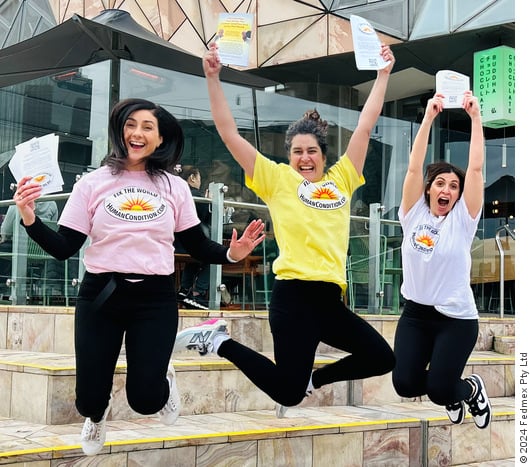 Desi, Angela and Nicole jumping while handing out ‘Fix The World’ flyers in Federation Square, Melbourne