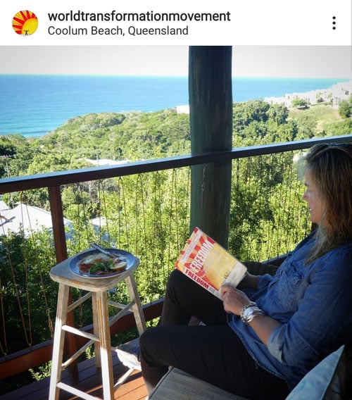 Instagram post of person reading the book FREEDOM with Coolum beach in the background
