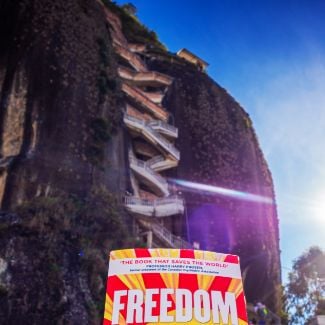FREEDOM book in front of Rock of Guatape - World Transformation Movement Commendations