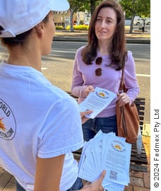 A person distributing WTM flyers to a person