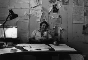 Jeremy Griffith as a young man at his desk in his writing room smiling