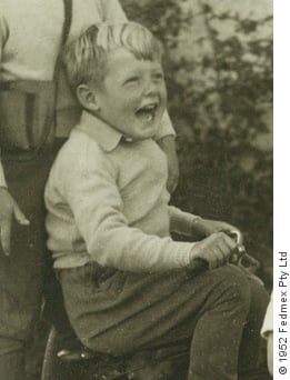 Image of Jeremy Griffith as a child on a tricycle watching a plane fly over