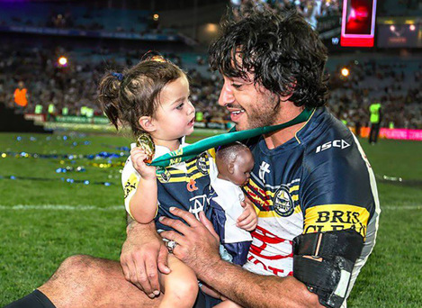 Australisch Rugby League superster Johnathan Thurston viert het winnen van de grote finale van 2016 door zijn team met zijn dochter Frankie