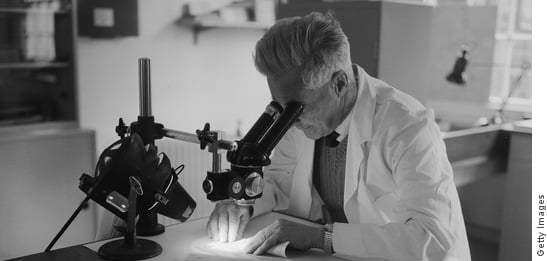 Scientist peering into a microscope