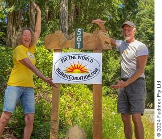 Bill and Cindy Mcaugherty next to a ‘Fix The World’ - poster at their driveway