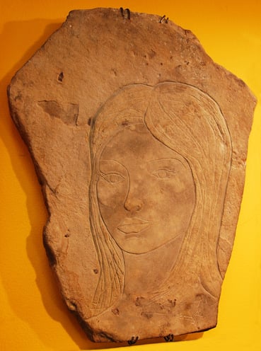 A stone carving by Jeremy Griffith of a young women’s face
