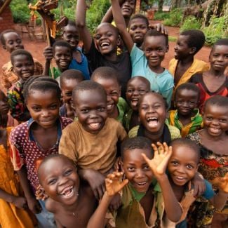 Happy Ugandan children waving