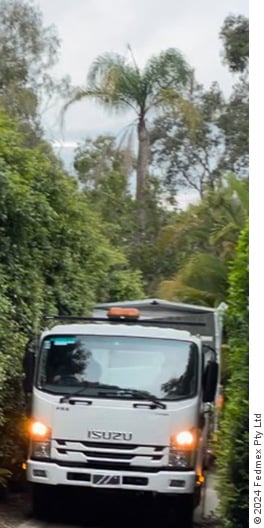 Vanhome being towed by truck on narrow road