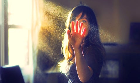 Woman looking at her hand in sunlight