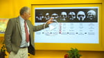 Jeremy Griffith pointing to a diagram of skull evolution pictures during a presentation