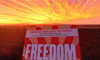 Cloud lit sunrise and front cover of the book titled FREEDOM by Jeremy Griffith
