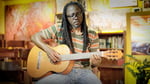 Franklin Mukakanga playing the guitar in a studio