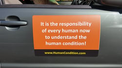 Big magnet on car door with the text ‘It is the responsibility of every human now to understand the human condition!