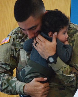 Solider with child displaying the contradictions of a man's life