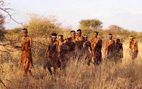 Bushmen women and children walking ina line