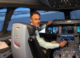 David sitting in the pilot seat of the cockpit of an aeroplane
