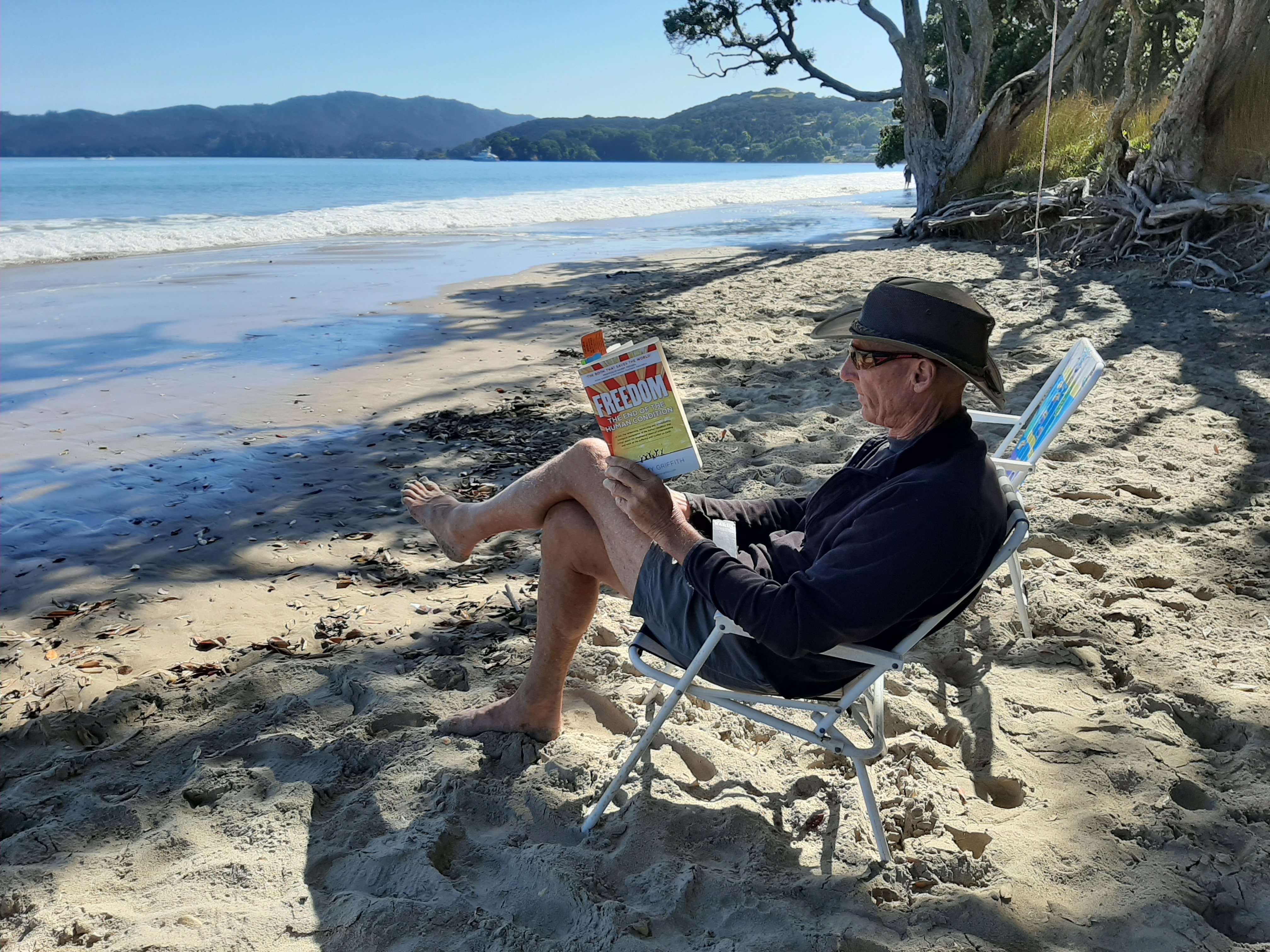 Doug Gibbs reading FREEDOM on beach