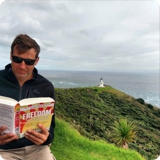 Man reading FREEDOM near lighthouse